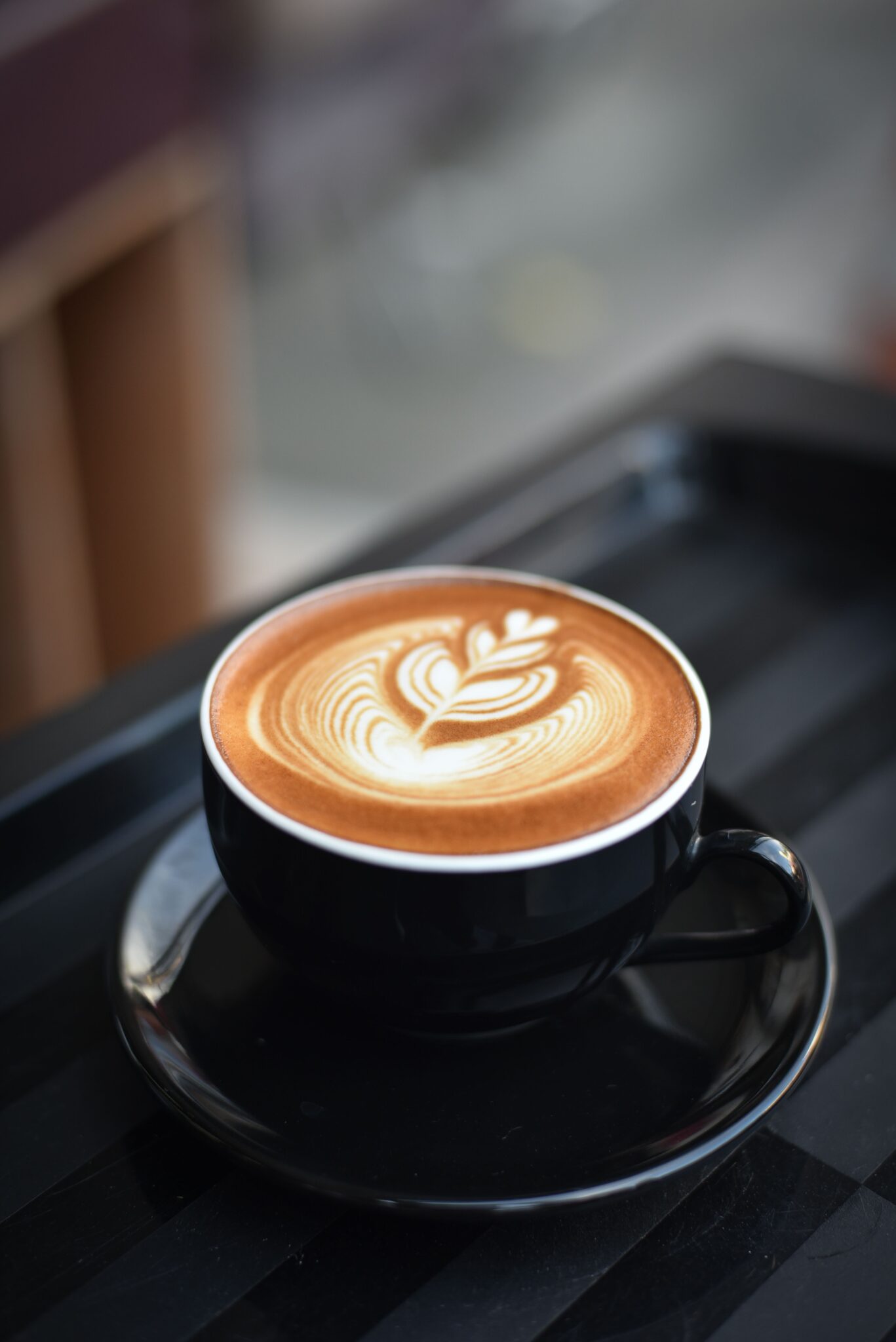 Чашка свіжозвареної чорної кави на дерев'яному столі вранці